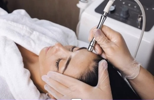 Woman receiving a microdermabrasion facial treatment with diamond-tip wand